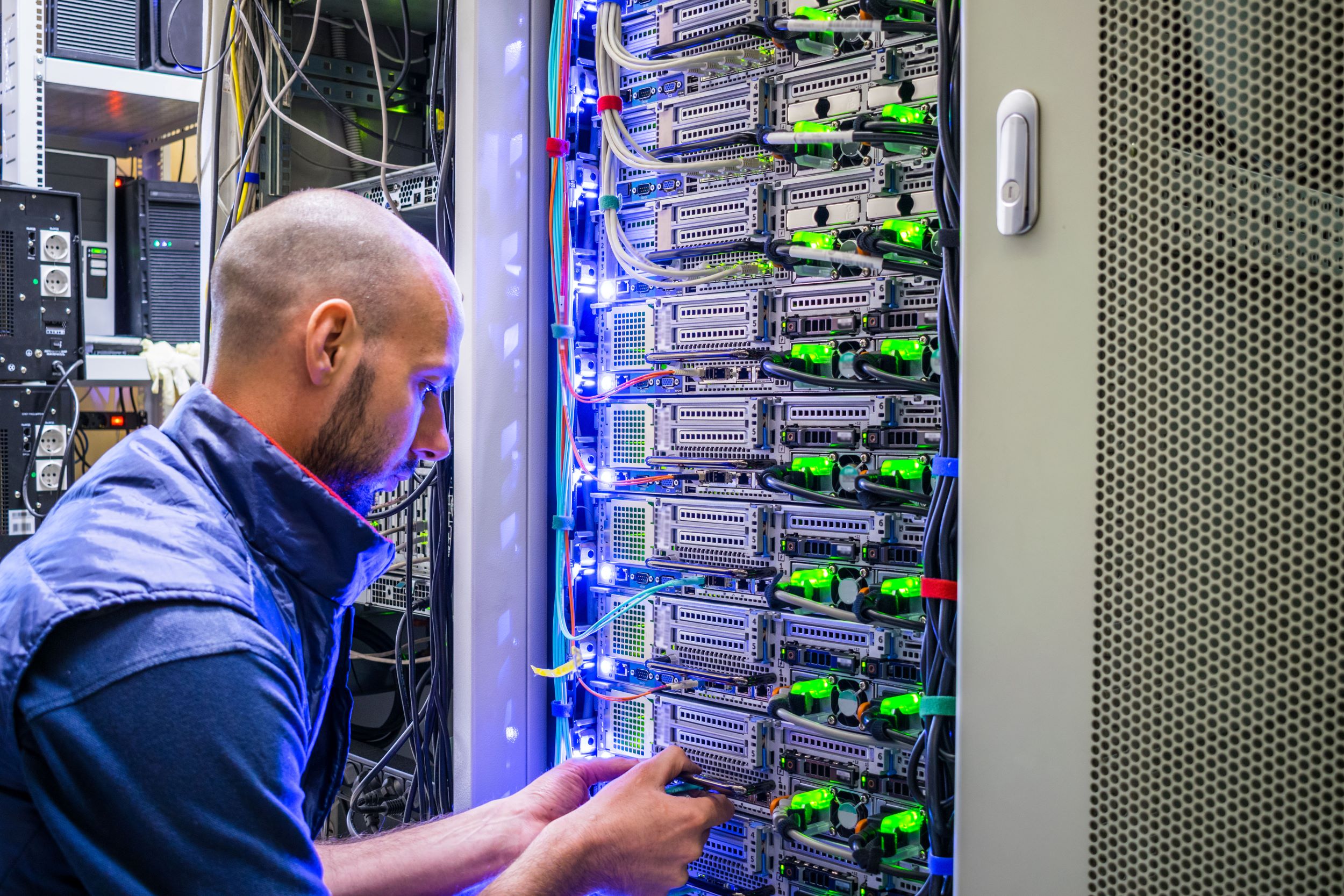 A specialist connects the wires in the server room of the data center