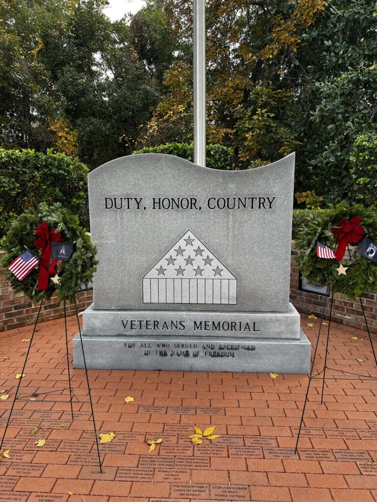 stone veterans memorial with wreaths on each side